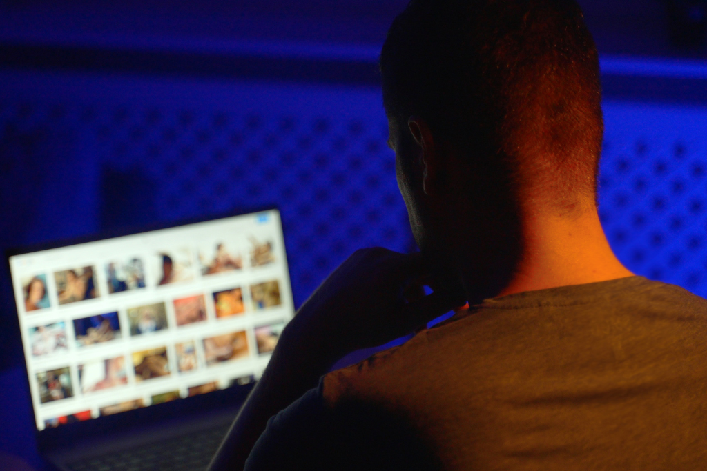 Man with potential porn addiction browsing porn site late at night.