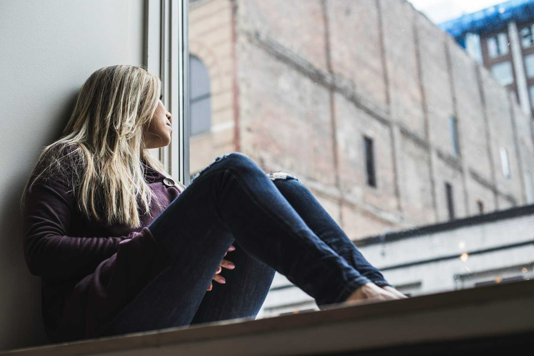 Woman looking out a window, depicts the topic of Recovering Alcoholics and Healthy Relationships,