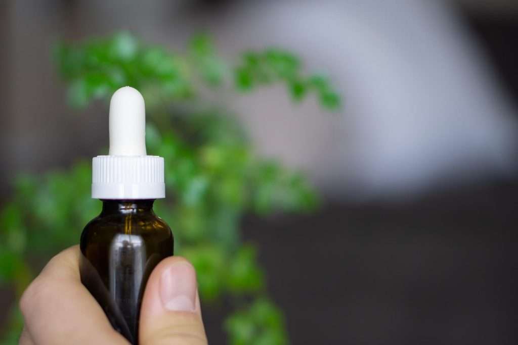 Person Holding White and Brown Bottle of CBD oil for anxiety