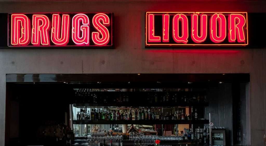 Bar signs with neon words "drugs" and "liquor". What drugs are the most addictive