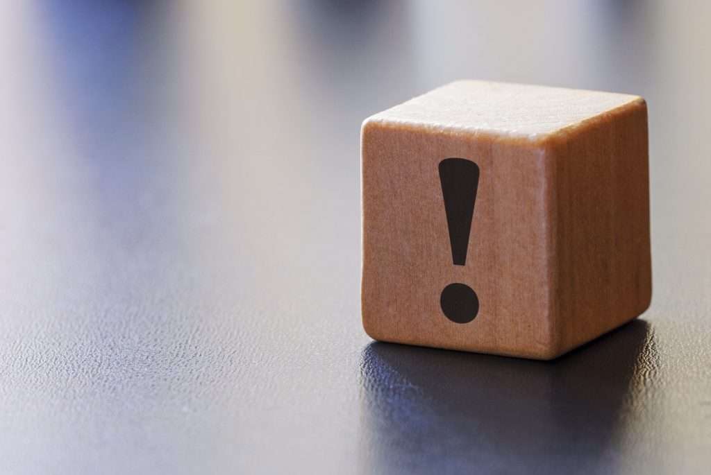 warning exclamation mark on a wooden block, naproxen and alcohol