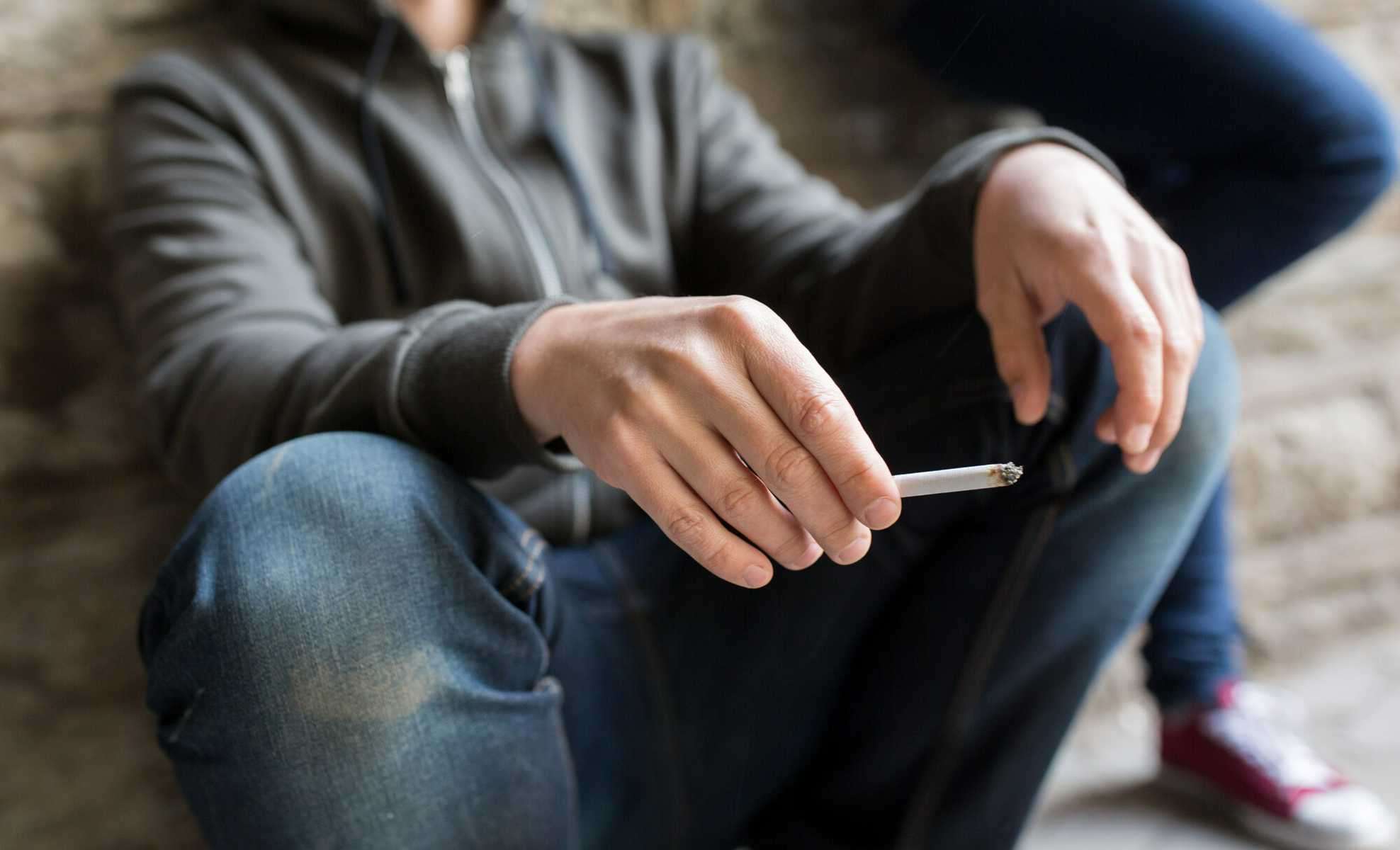 person sitting with a cigarette in their hand, signs of drug addiction