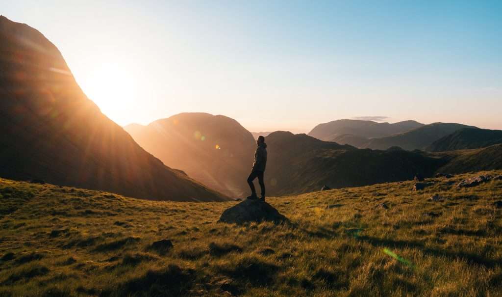 person hiking in mountainous landscape, coping skills for addiction